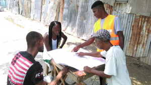 Mapping and verification assistant Akeem, who was promoted to Junior Land Surveying Technician, sharing his map with community members for their feedback and corrections.